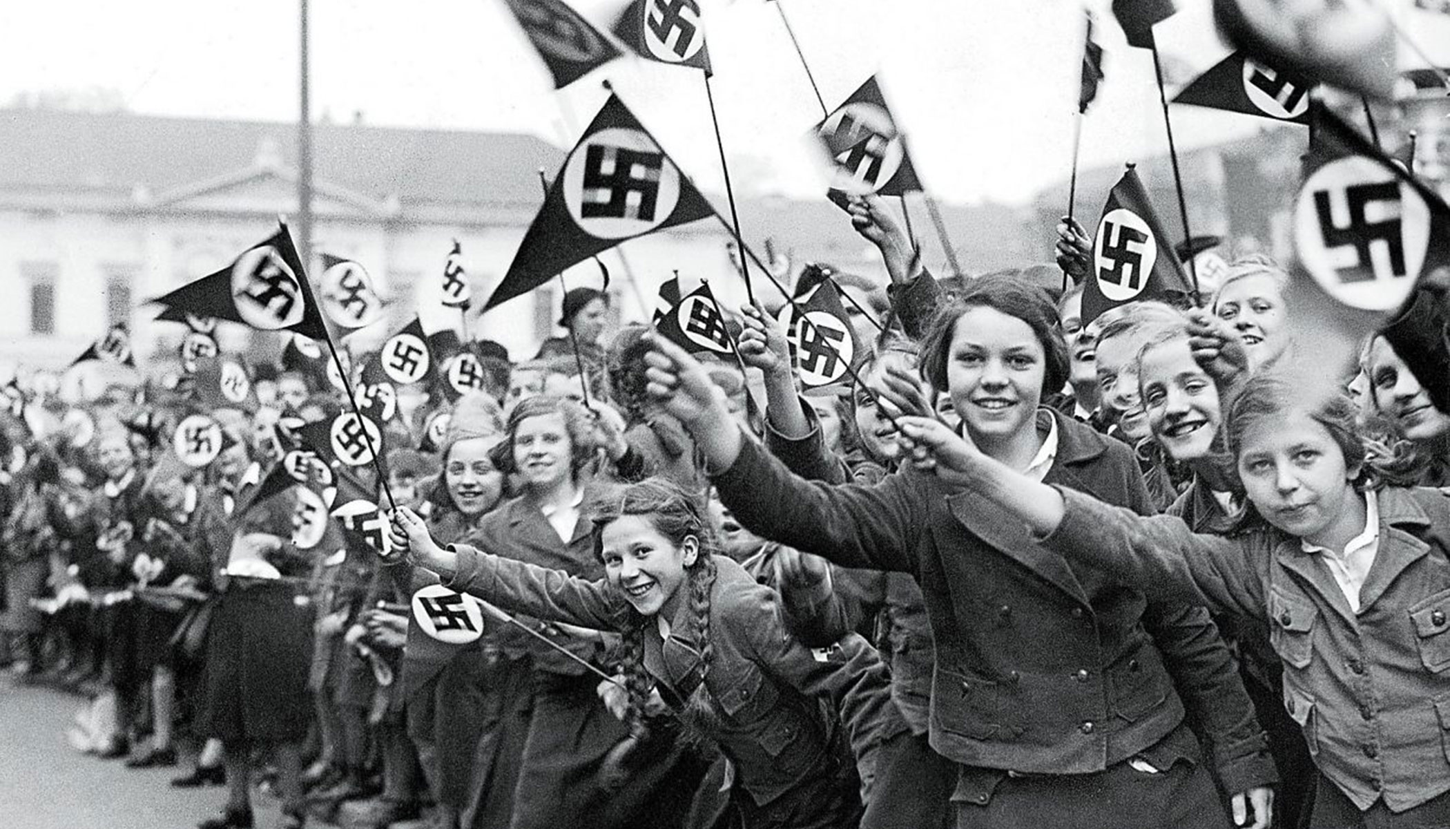 Members of the League of German Girls wave Nazi flags in support of the German annexation of Austria. Vienna, Austria, March 1938.